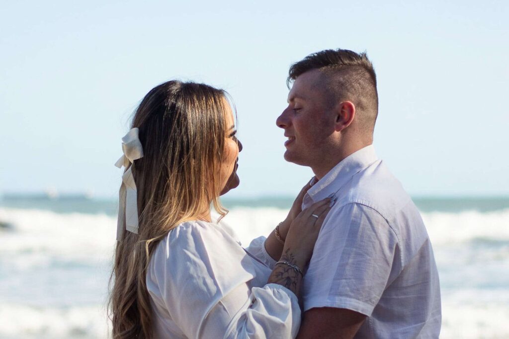 Casal posando para ensaio fotográfico de casal pré wedding na praia