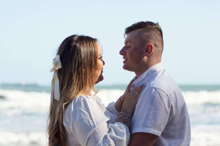 Casal posando para ensaio fotográfico de casal pré wedding na praia