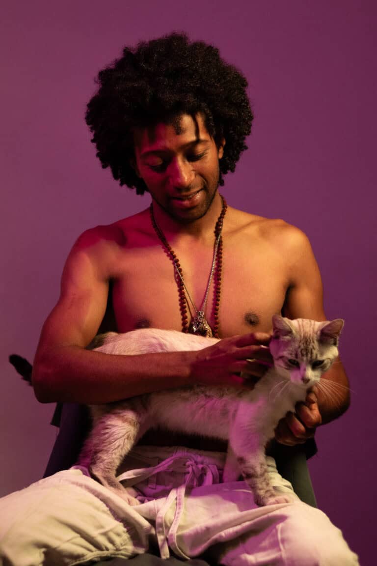Fotógrafo com gato em estúdio com iluminação colorida.