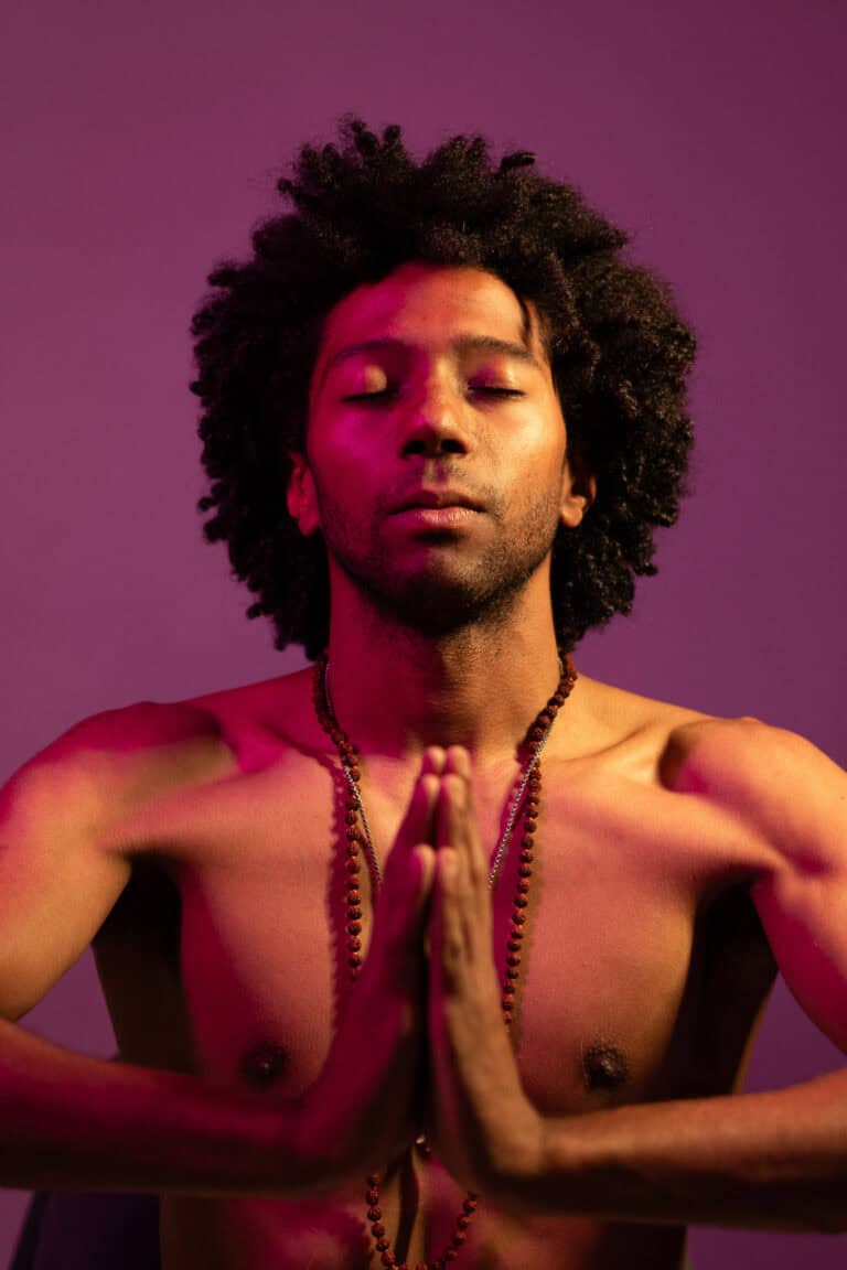 Fotógrafo Guilherme Marques captura um homem em postura de meditação com fundo roxo.