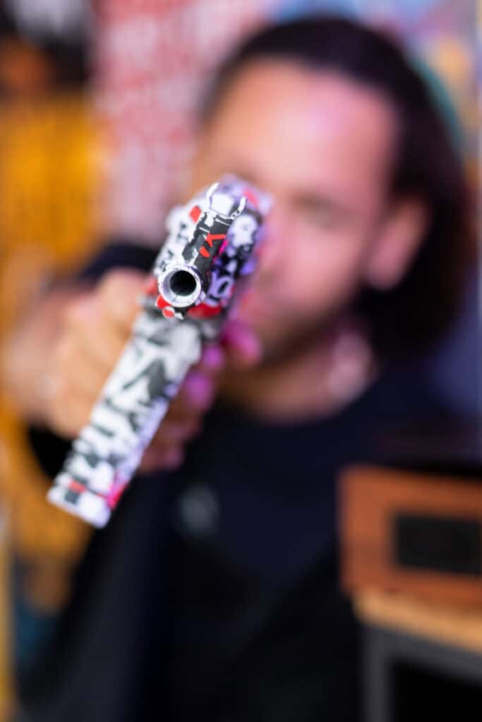 Fotógrafo Guilherme Marques com arma de fogo colorida.