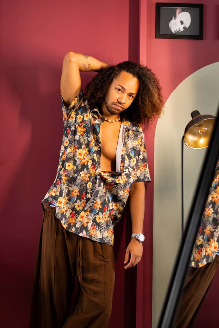 Fotógrafo Guilherme Marques captura retrato de homem com cabelo cacheado em ambiente com decoração m.