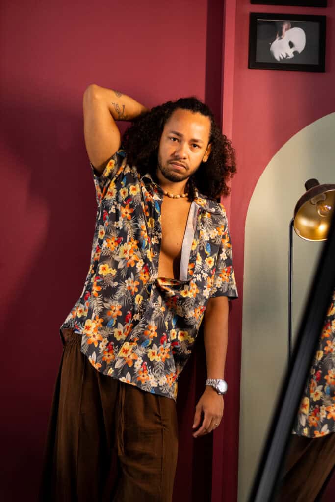Fotógrafo Guilherme Marques em ensaio com estilo casual e fundo colorido.