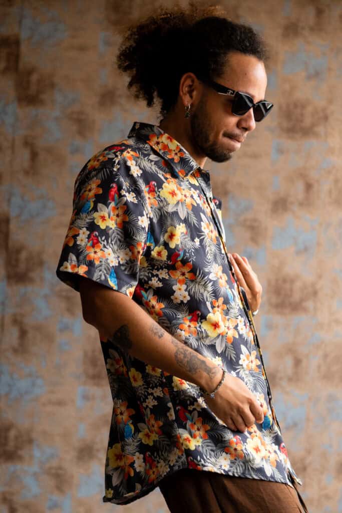 Fotógrafo Guilherme Marques retratando homem com camisa floral e óculos escuros.