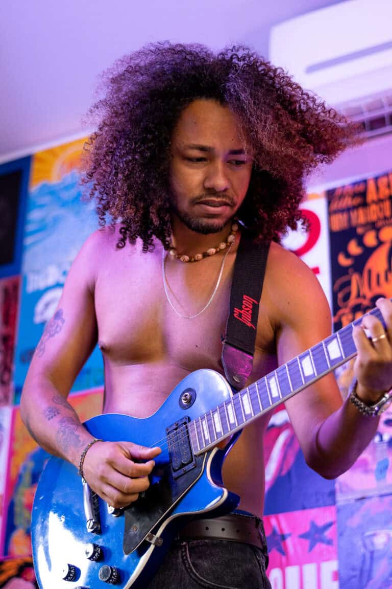 Guitarrista tocando ao vivo em estúdio de fotografia profissional.