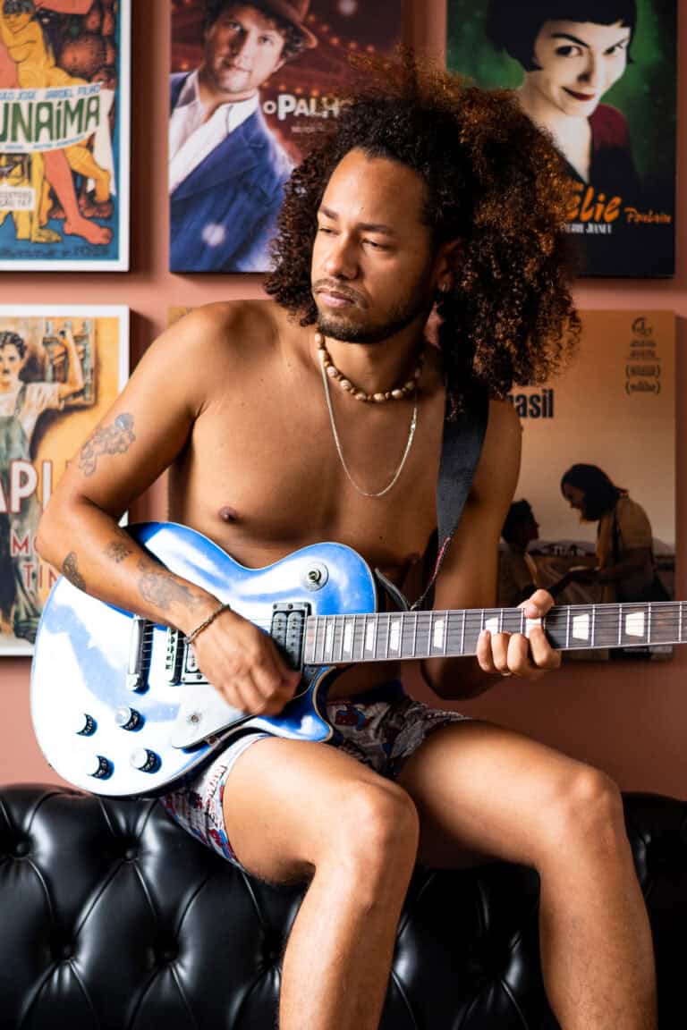 Fotógrafo Guilherme Marques, retrato de músico tocando guitarra em ambiente artístico.