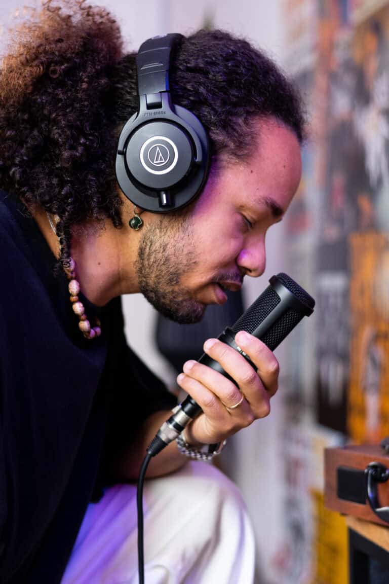 Fotógrafo profissional com fone de ouvido, capturando áudio em estúdio.