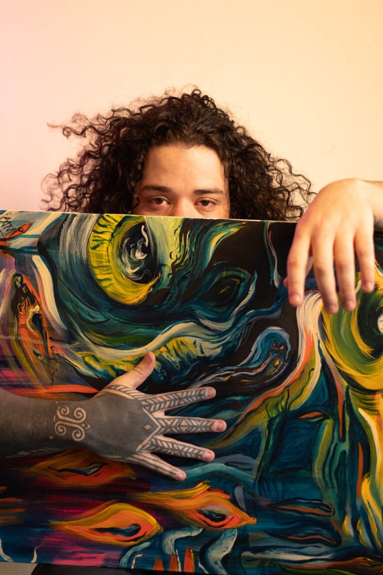 Retrato de artista com pintura abstrata, destacando o talento do fotógrafo Guilherme Marques em capt.