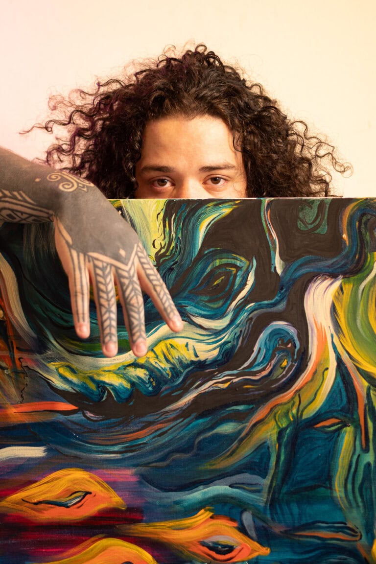 Fotógrafo Guilherme Marques com obra de arte abstrata.