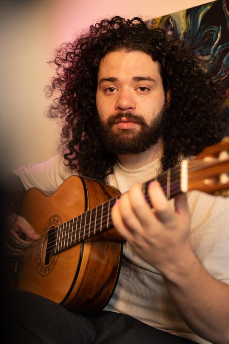 Fotógrafo Guilherme Marques tocando violão em ensaio artístico.