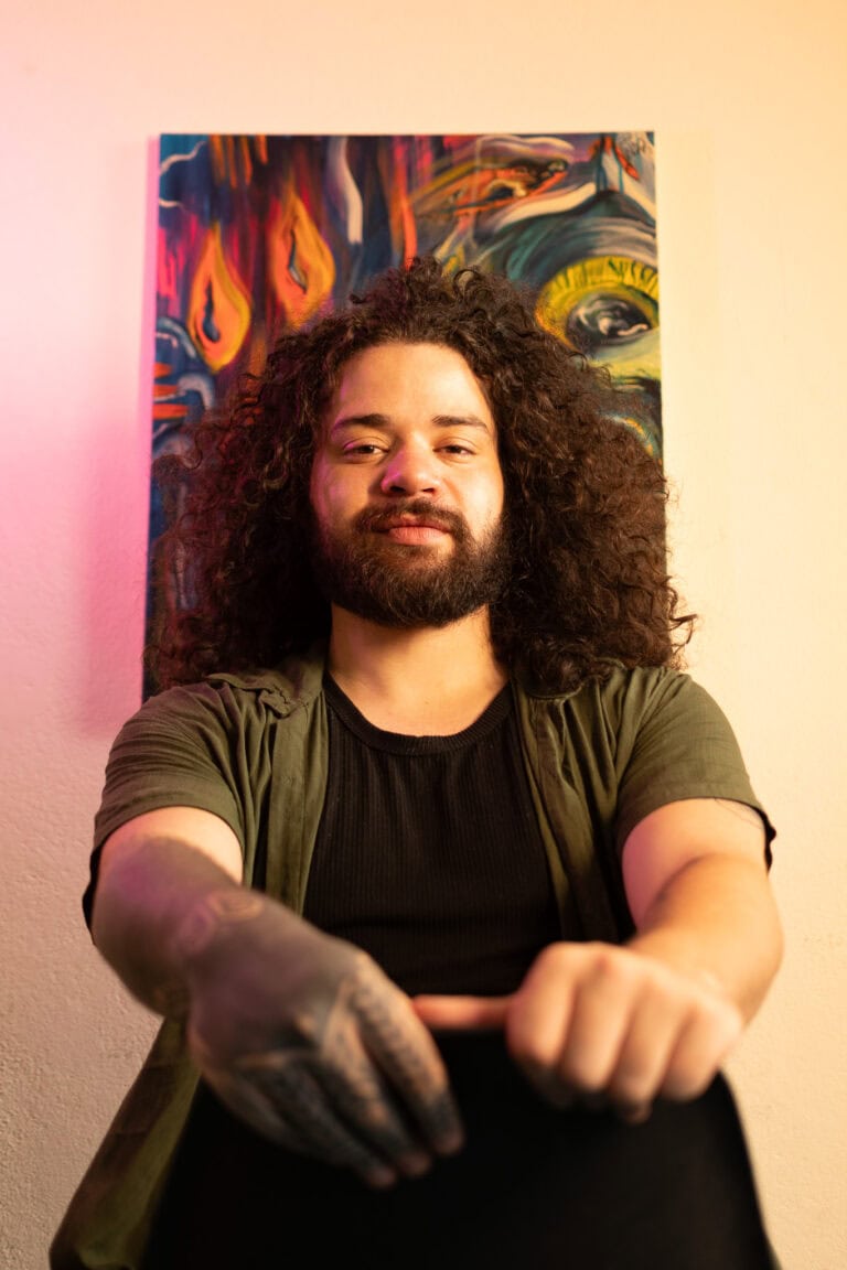 Fotógrafo Guilherme Marques em ensaio artístico com fundo colorido.
