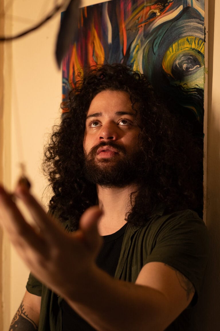 Fotógrafo Guilherme Marques em ensaio artístico com fundo de pintura colorida.