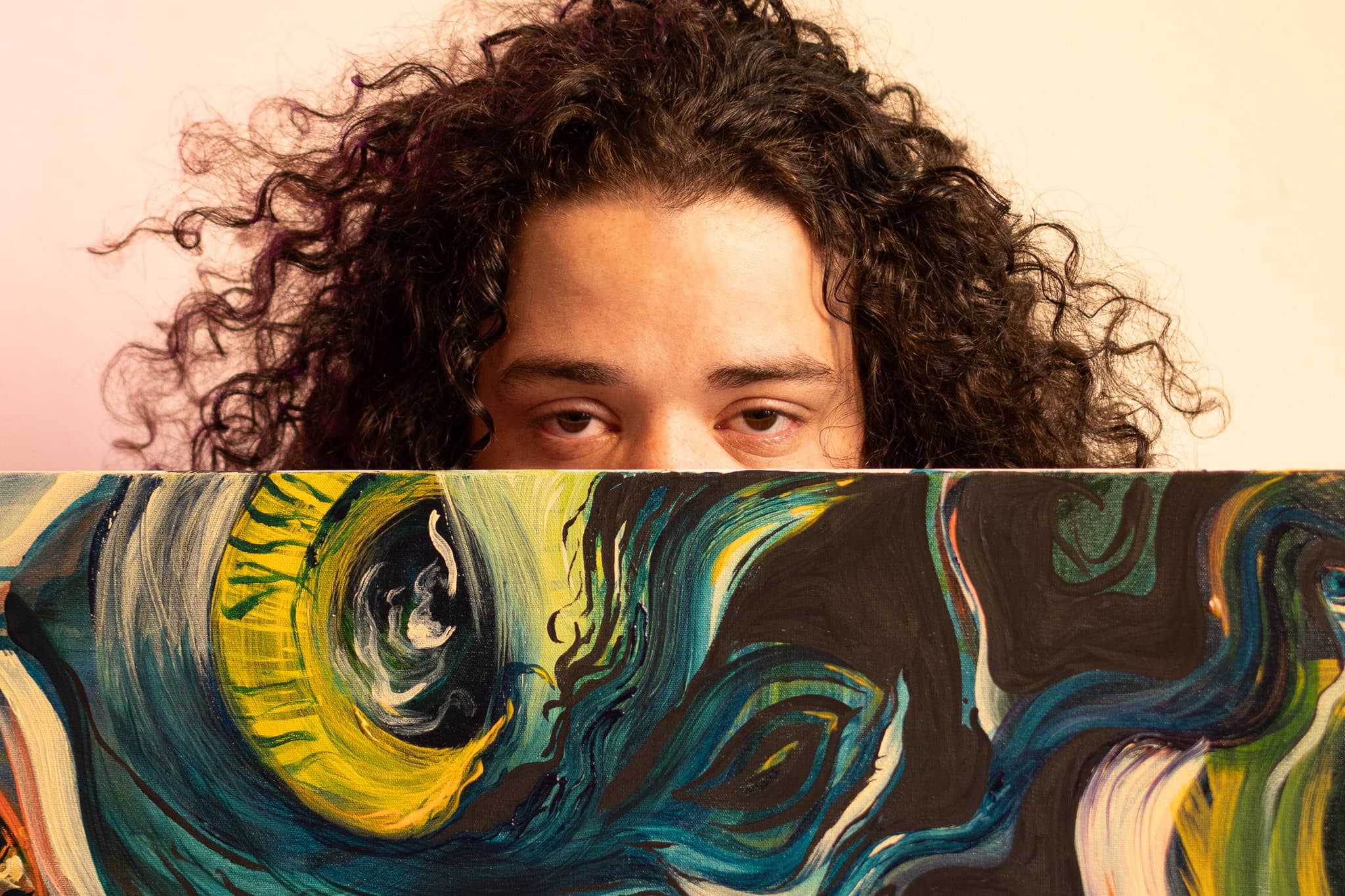 Retrato de pessoa com cabelo cacheado segurando obra de arte abstrata, simbolizando profundidade sim.