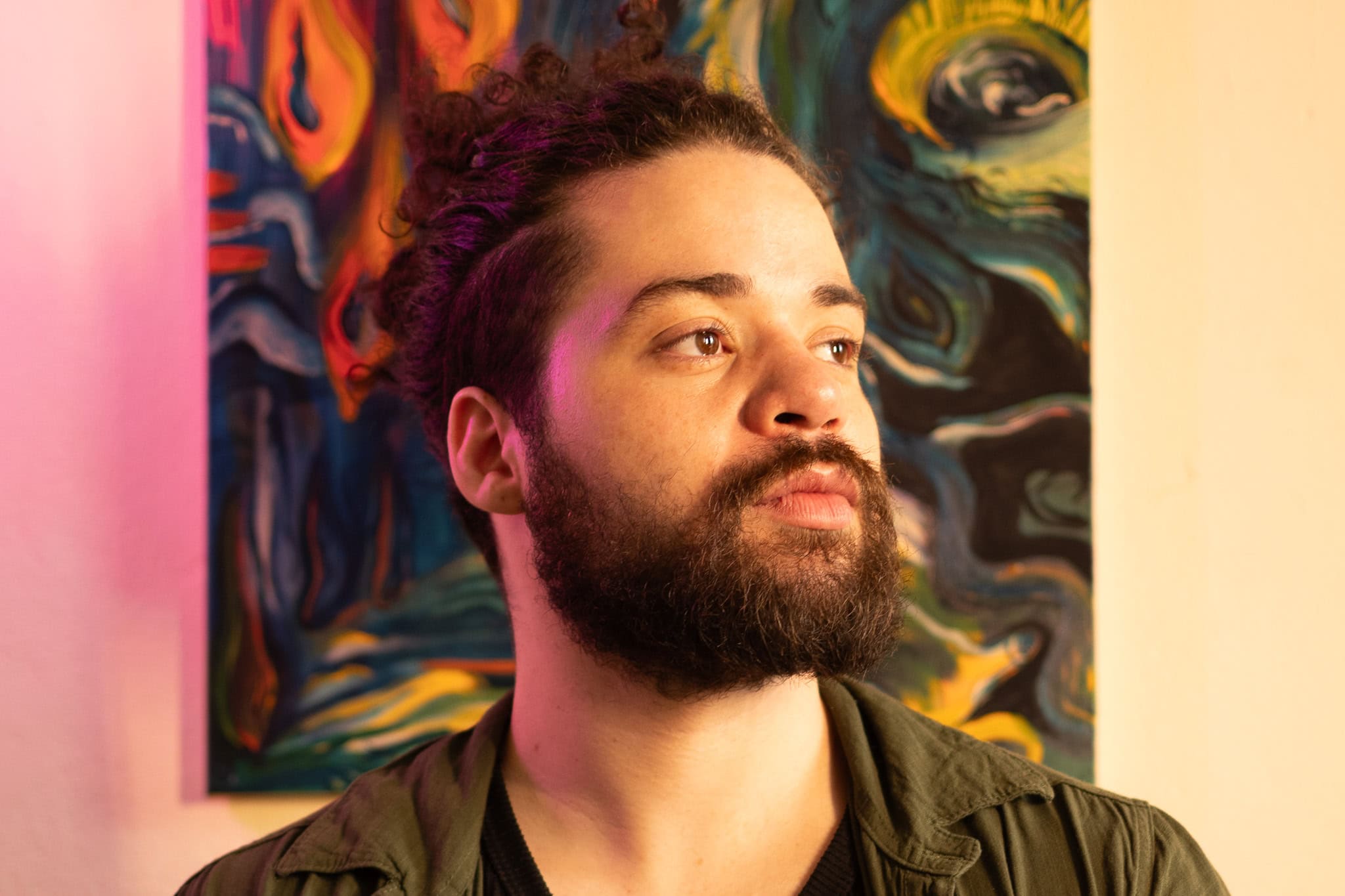 Retrato de músico com fundo artístico vibrante, ideal para ensaio fotográfico musical, destacando a.