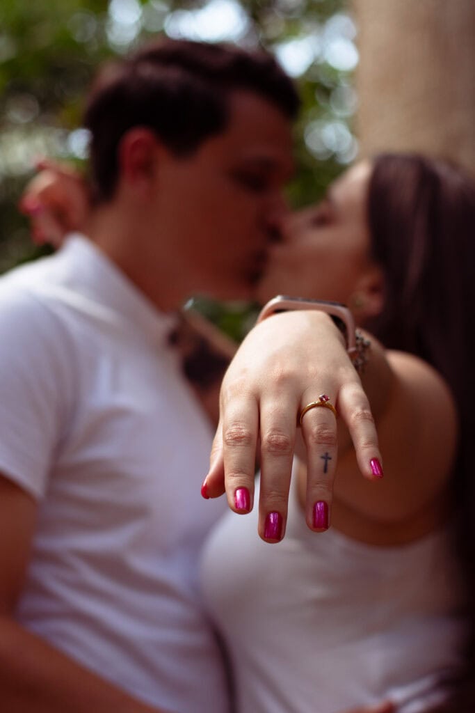 Foto de casal apaixonado em ensaio ao ar livre, destacando a fotografia de Guilherme Marques em parq.