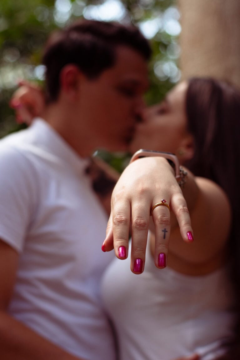 Foto de casal apaixonado em ensaio ao ar livre, destacando a fotografia de Guilherme Marques em parq.