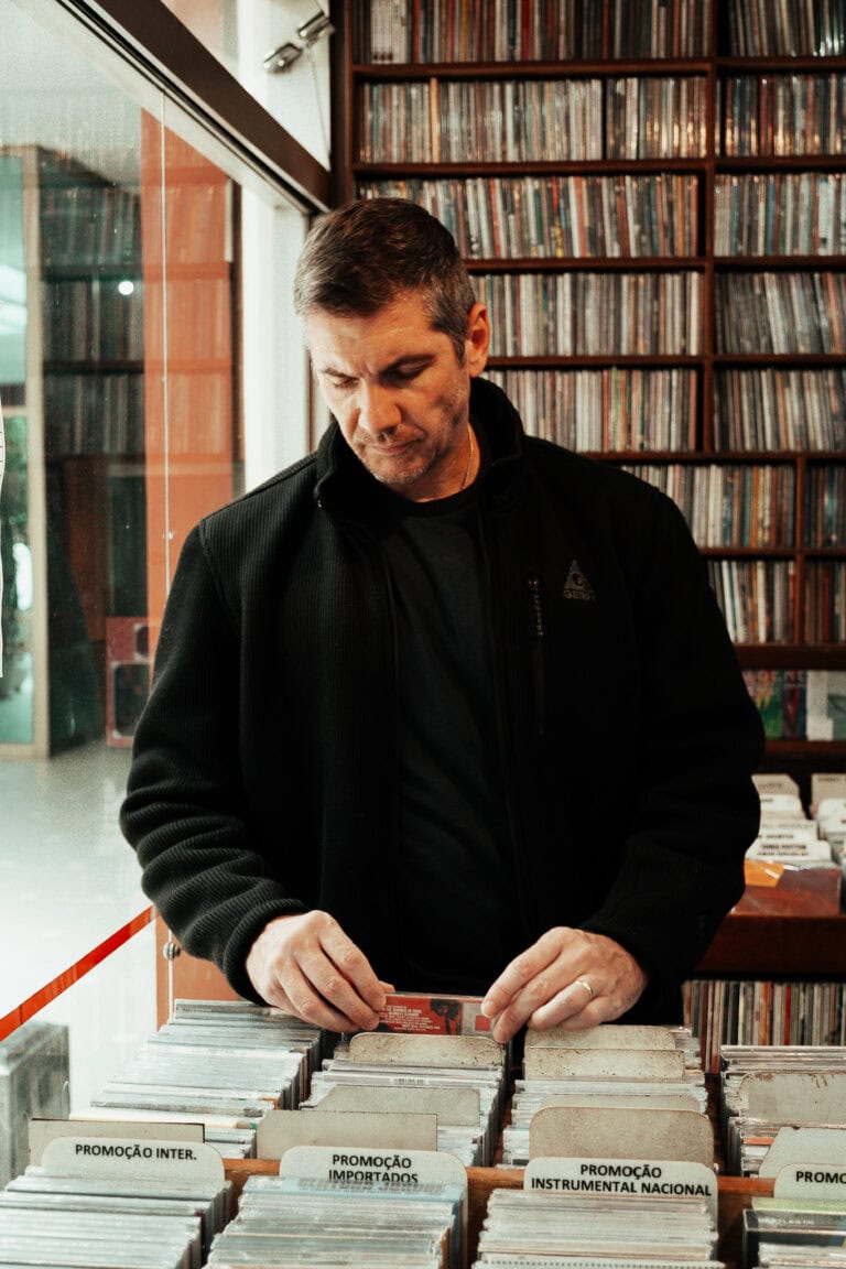 Fotógrafo Guilherme Marques em estúdio de fotos com livros ao fundo.