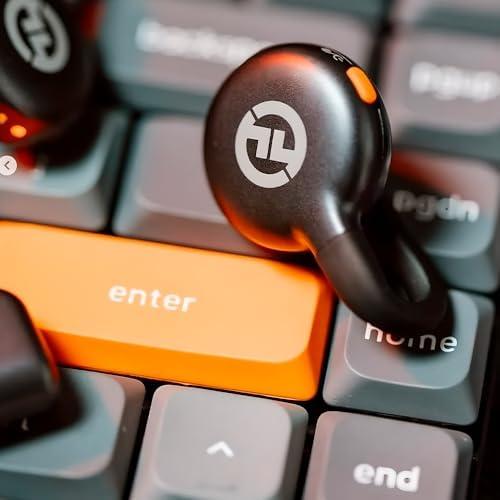 Imagem de um fone de ouvido sobre teclado de computador com botão laranja.