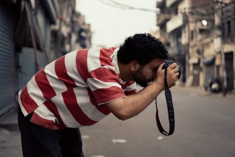 Man capturing photos in the streets of Ludhiana, Punjab, showcasing local architecture.