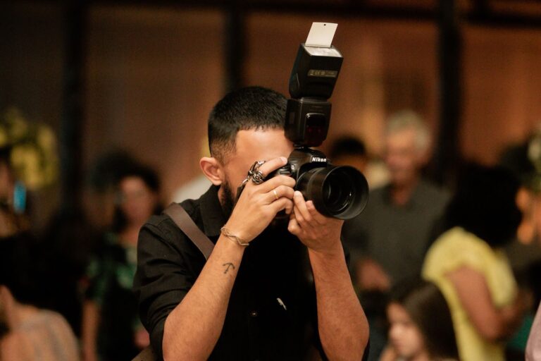 A photographer captures moments at an indoor event in Alpinópolis, Brazil.