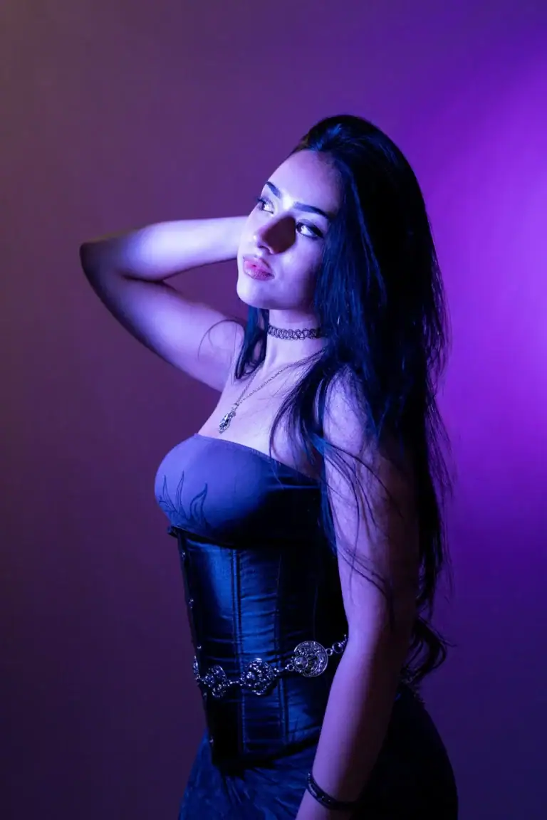 Retrato de mulher com cabelo longo sob luzes roxas e azuis.