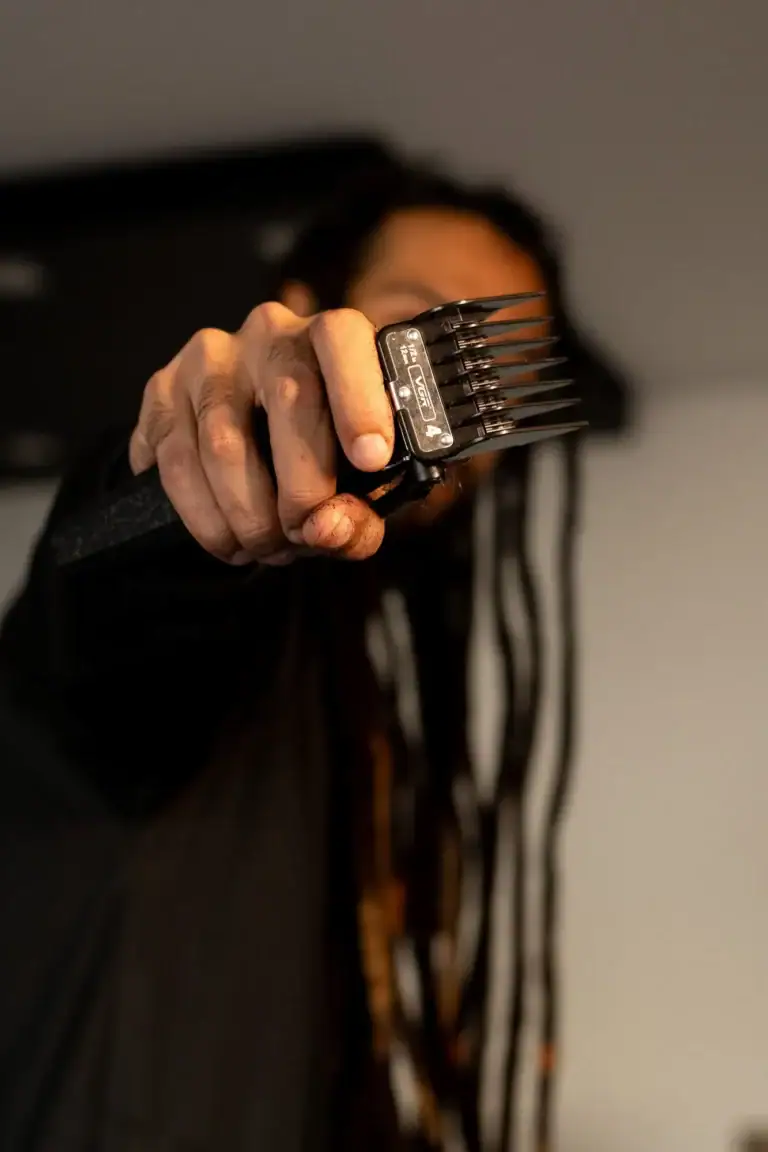 Homem segurando um pente de cabelo com foco na ferramenta.