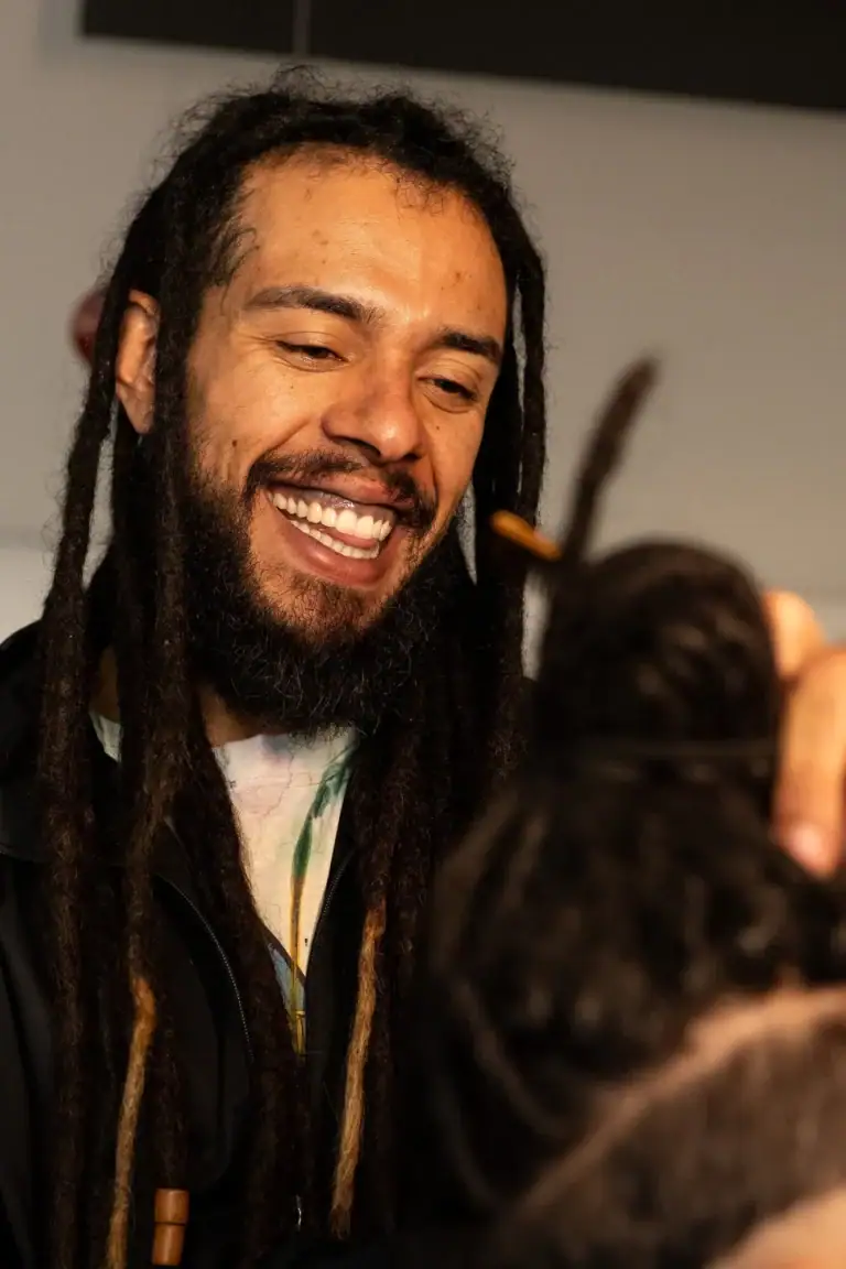 Fotógrafo Guilherme Marques sorrindo durante sessão de fotos ao ar livre.