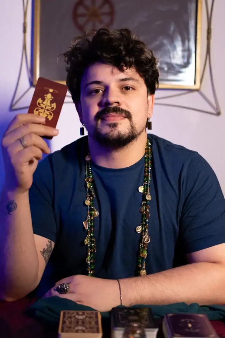 Fotógrafo Guilherme Marques com baralho, em ambiente artístico e criativo.