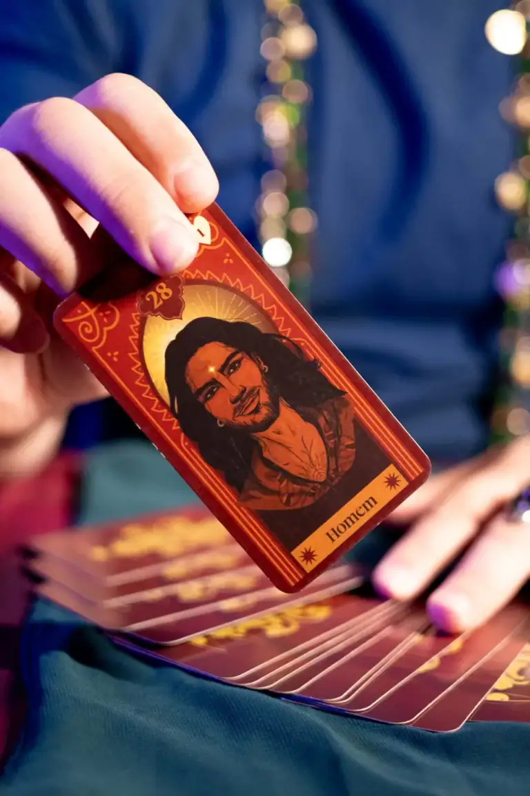Imagem de uma pessoa segurando uma carta de tarô com ilustração de Jesus Cristo.