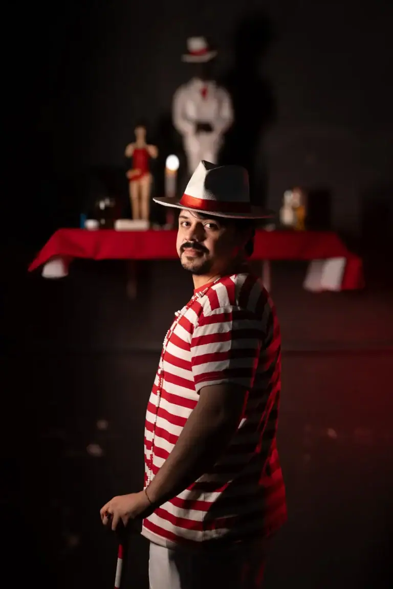 Fotógrafo Guilherme Marques com homem de chapéu em estúdio com objetos de cena.