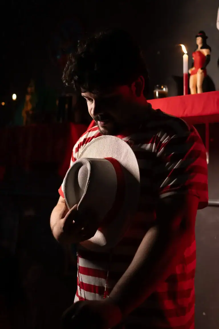 Fotógrafo Guilherme Marques captura cena teatral com iluminação dramática e figurinos vibrantes.