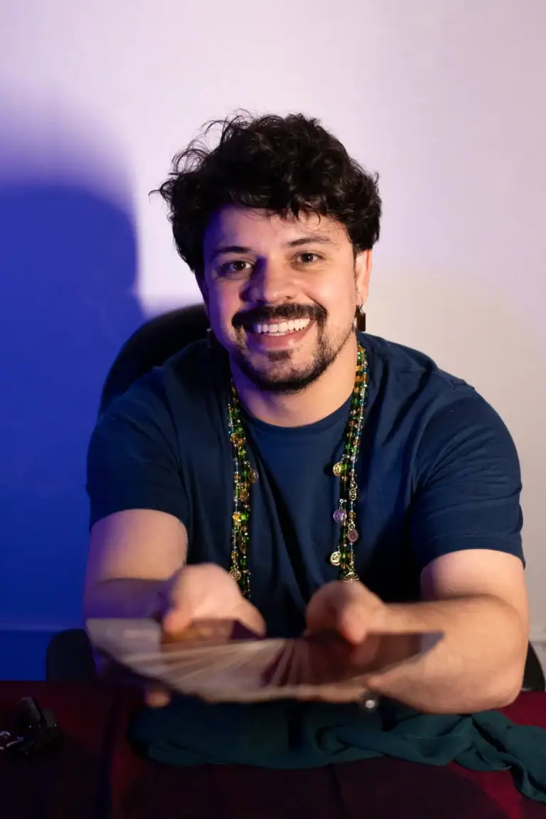 Fotógrafo Guilherme Marques sorrindo, retrato profissional com fundo colorido.